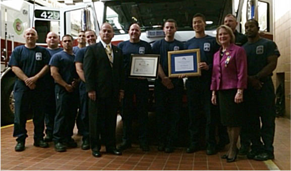 President Bill Price and DAR member Marsha Price present flag certificates to the staff of Fire Station 29